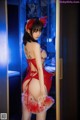 A woman in a red lingerie is standing in a doorway.