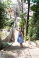 A woman in a blue dress standing on some steps.