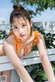 A woman in an orange bathing suit sitting on a white bench.