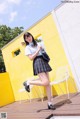 A woman in a school uniform is posing for a picture.