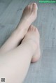 A woman's bare feet on a wooden floor.