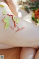 A close up of a woman's legs with flowers on them.